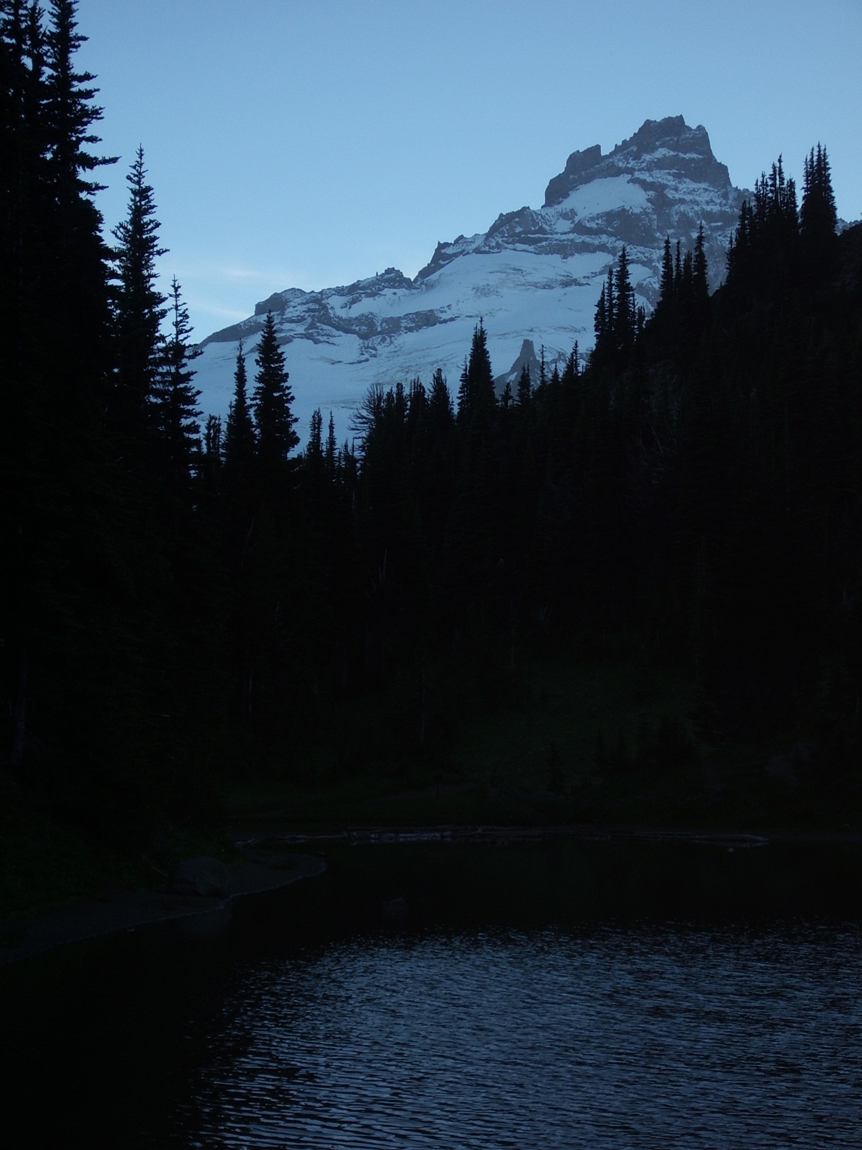 dark mt rainier behind lake