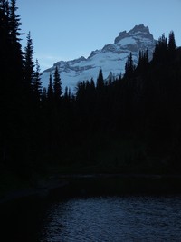 dark mt rainier behind lake