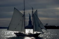sailing ship in front of Statue of Liberty